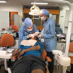 fotografía de dos especialistas revisando la boca de un paciente