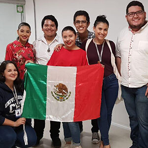 fotografía de varias personas sosteniendo una bandera del país de México